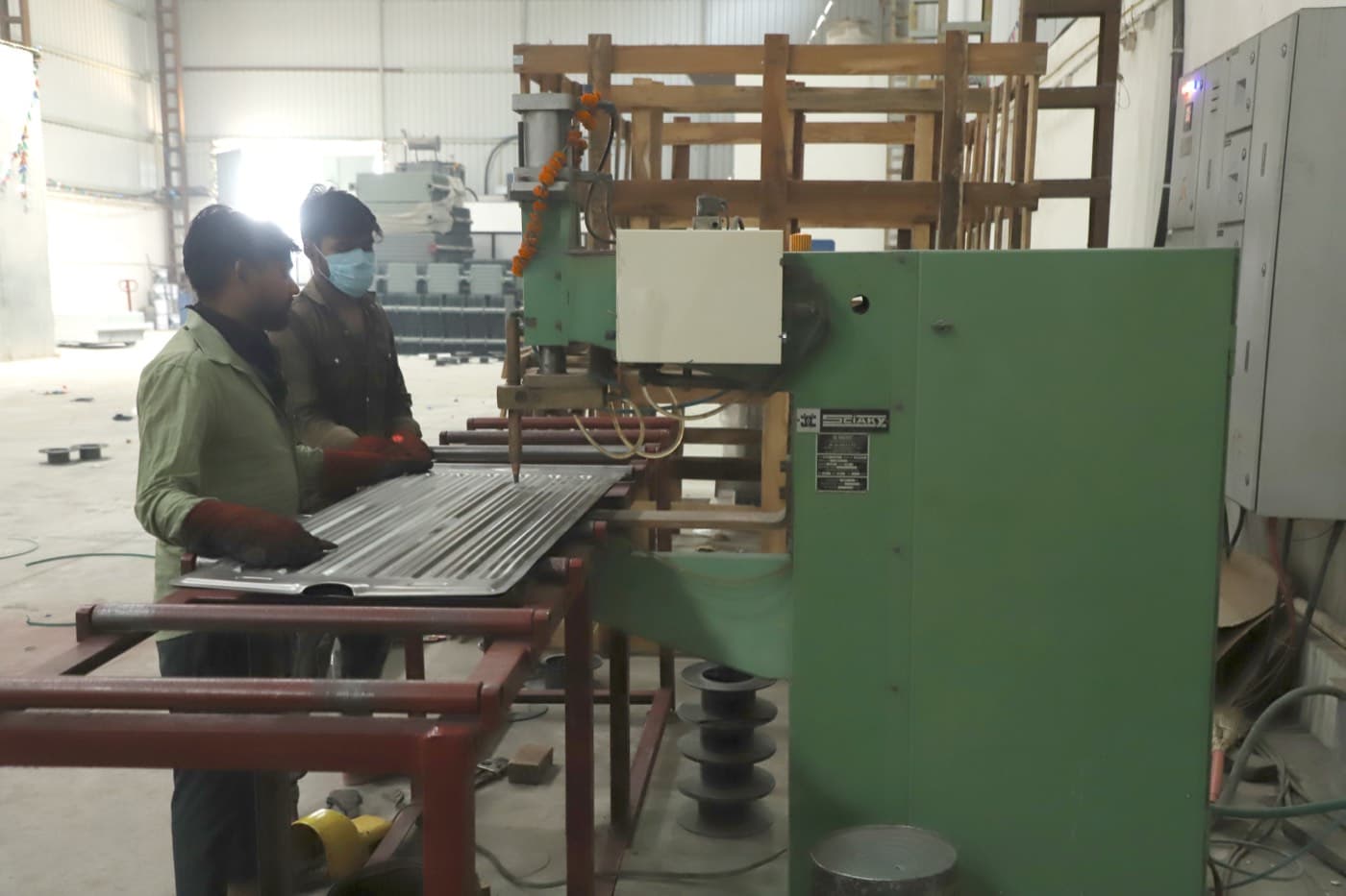 Pressed steel radiator panel being formed for electrical equipment manufacturers